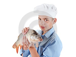 Young boy prepare a fish carp on white background