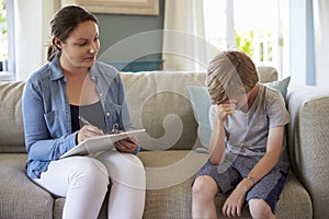 Young Boy With Problems Talking With Counselor At Home