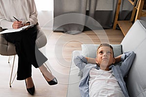 Young boy with problems talking with psychologist at medicine office