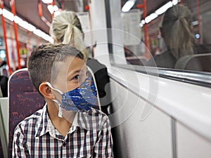 Young boy with protective mask travels by subway, Prague
