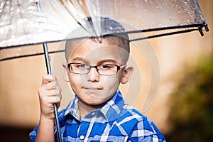 Young boy in the rain with umbrella