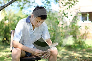Young Boy Reading Book outdoors