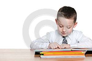 Young boy is reading at the desk