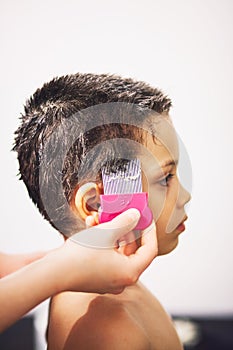 Young boy receiving lice treatment