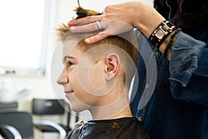 Young boy with red hair getting a haircut
