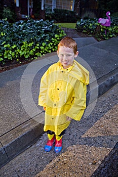 Young boy with red hair playing in the rain