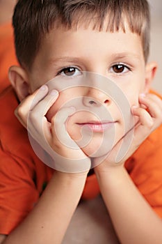 Young boy relaxed smiling with hands on chin