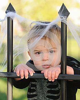 Young boy resting against fence