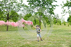 Young boy running trailing a pink smoke flare