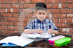 Young boy sharpening the pencil in classroom while attending class in primary School