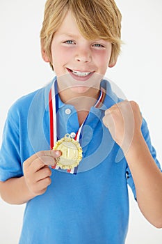 Young boy showing off medal