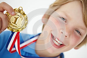 Young boy showing off medal