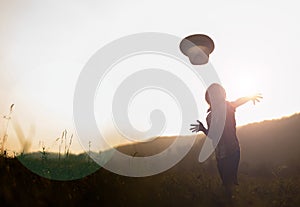 Young boy silhouette in landspace at sunset