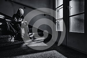 A young boy sitting alone on a stairs