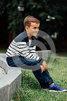 Young boy sitting on curb