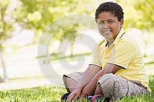 Young boy sitting outdoors