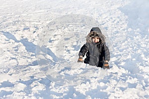 Young boy sitting on the snow
