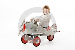 Young Boy Sitting In Toy Aeroplane photo