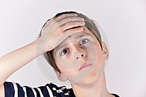 Young boy slapping hand on head