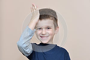 Young boy slapping hand on head