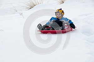 Young boy sledding in snow