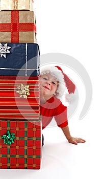 Young boy smiling behind presents