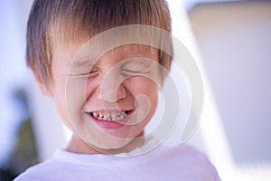 Young boy smiling eyes closed