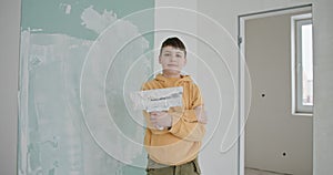 Young Boy Smiling During Home Renovation, Painting Walls