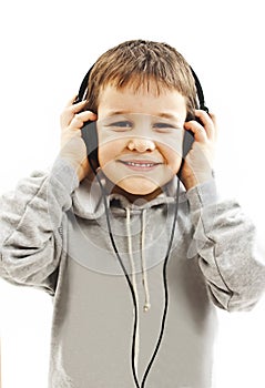 The young boy is smiling and listening to music