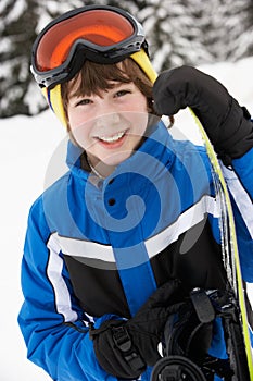 Young Boy With Snowboard On Ski Holiday