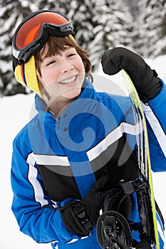 Young Boy With Snowboard On Ski Holiday