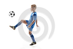 Young boy with soccer ball doing flying kick