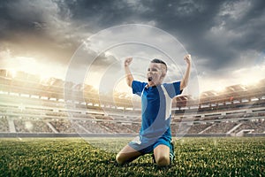 Young boy with soccer ball doing flying kick at stadium