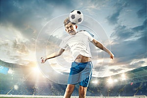 Young boy with soccer ball doing flying kick at stadium
