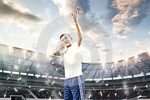 Young boy with soccer ball doing flying kick at stadium