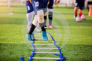 Young boy soccer players Jogging and jump between ladder drills
