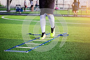 Young boy soccer players Jogging and jump between ladder drills for football training. Ladder drills exercises for football or