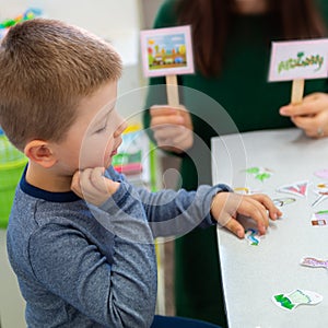 Young boy in speech therapy office. Preschooler exercising correct pronunciation with speech therapist. Child Occupational Therapy