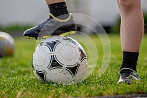 young boy standing on a ball on football field