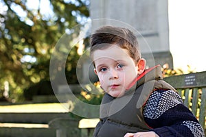 Young boy staring ahead with emotion on face