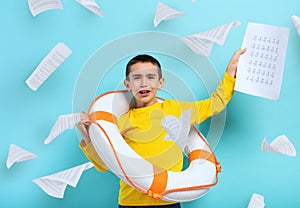 Young boy student is drowning in a sea of sheets of exercises. Cyan background