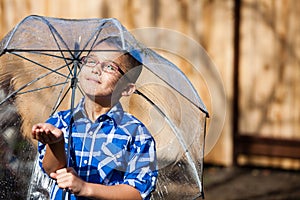 Young boy in a sun shower with umbrella
