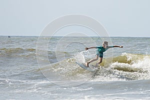 A young boy surfs waves on the Atlantic Ocean photo