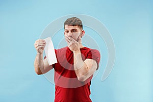 Young boy with a surprised expression bet slip on blue background