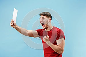 Young boy with a surprised expression bet slip on blue background