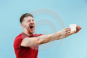 Young boy with a surprised expression bet slip on blue background