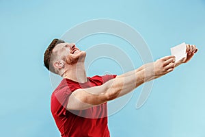 Young boy with a surprised expression bet slip on blue background