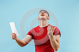 Young boy with a surprised expression bet slip on blue background