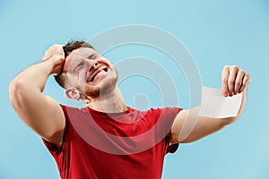 Young boy with a surprised expression bet slip on blue background