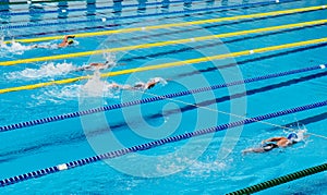 Young boy swimming Freestyle posture in the blue water pool.